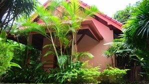 A building with a red roof surrounded by lush greenery. - The Happy Elephant Resort (Rawai)