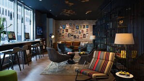 A modern lounge area with a bar, seating, and artwork on the walls. - Renaissance Montreal Downtown Hotel (Montreal)