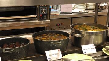 Ein Buffet mit verschiedenen Gerichten, darunter Hühnchen Dum Biryani, Kadai-Hühnchen und Reis.