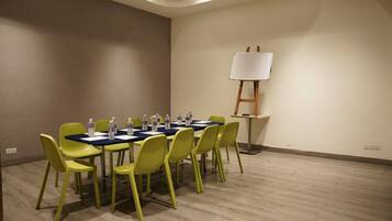 A conference room with a table, chairs, and a whiteboard.