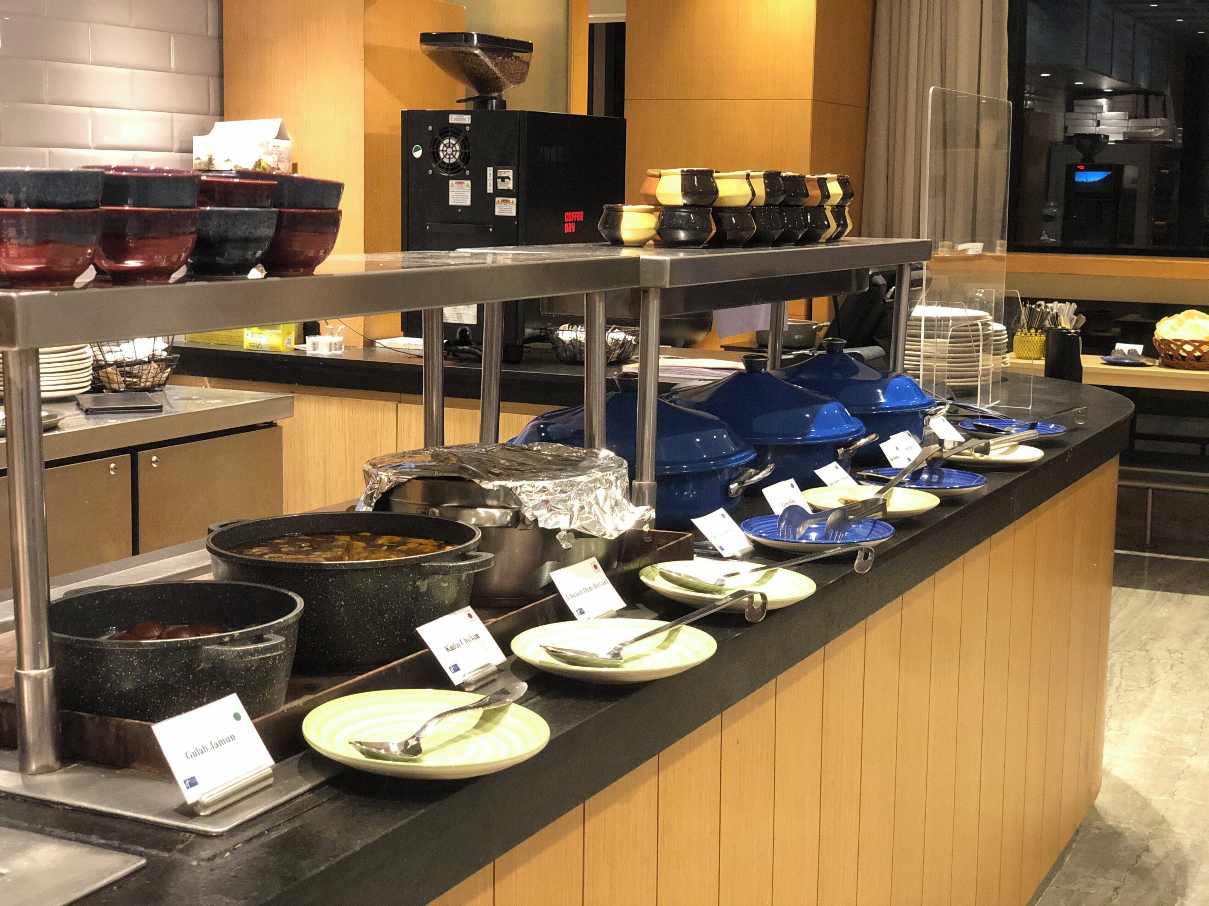 A buffet setup with various dishes and utensils.
