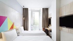 A hotel room with two beds, a TV, a desk, and a window with curtains. - Ibis Styles Jakarta Sunter (Jakarta)