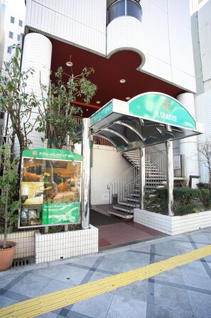 A hotel entrance with a covered staircase, a signboard advertising the hotel, and a tactile paving path for visually impaired visitors. - Hotel IL GRANDE Umeda (Osaka)