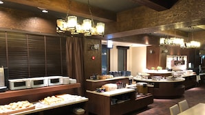A buffet setup with various food items and a coffee station.