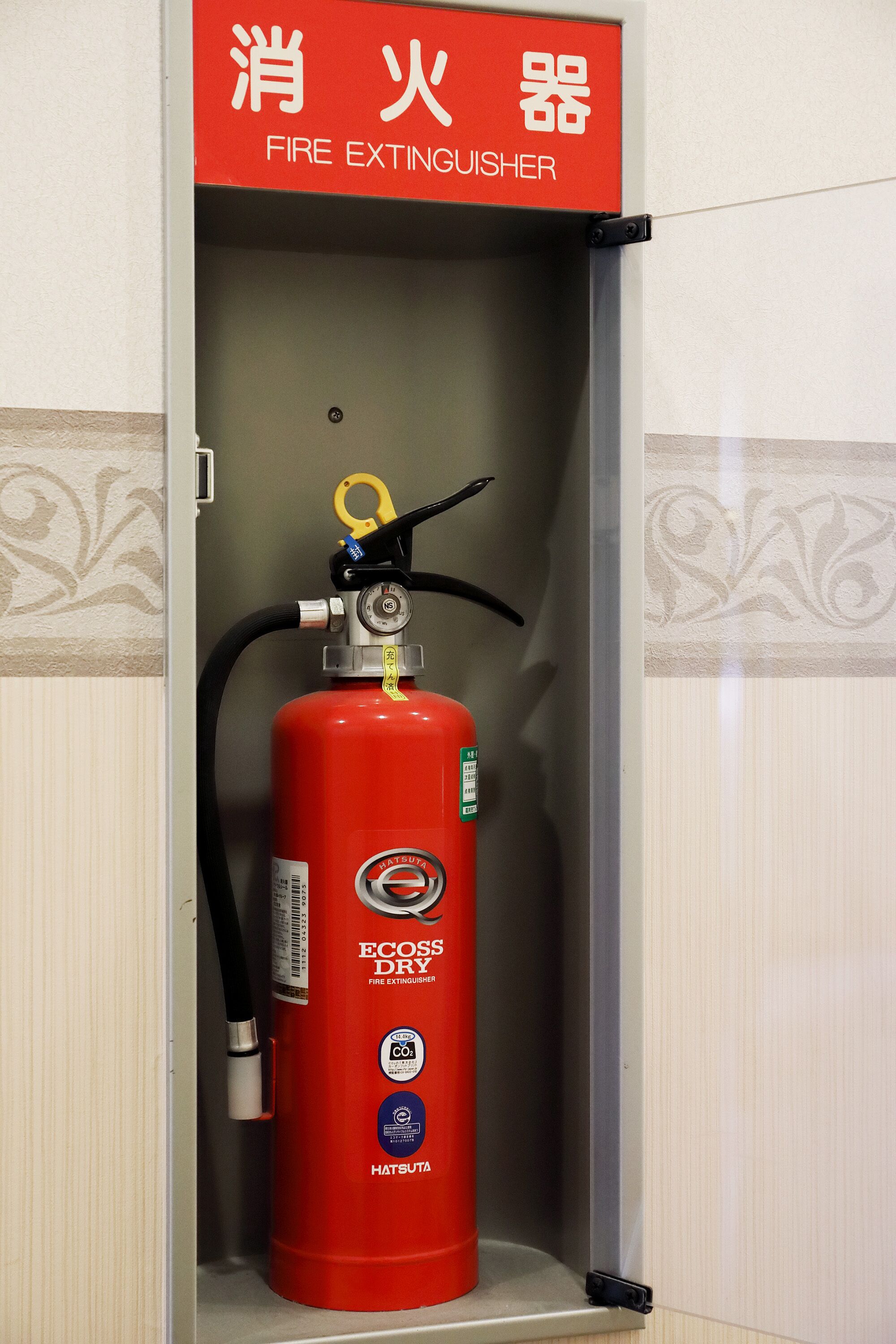 A fire extinguisher mounted on a wall with a sign above it reading "FIRE EXTINGUISHER".