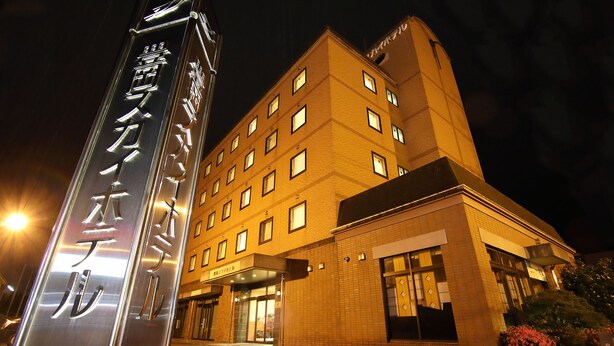 A hotel with a prominent sign, multiple windows, and a well-lit entrance. - Toyooka Sky Hotel (Toyooka)