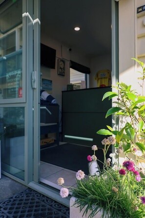 A room with a bed, a desk, and a chair. There is a window with a view of the outside. - La Rochelle Motel (Akaroa)