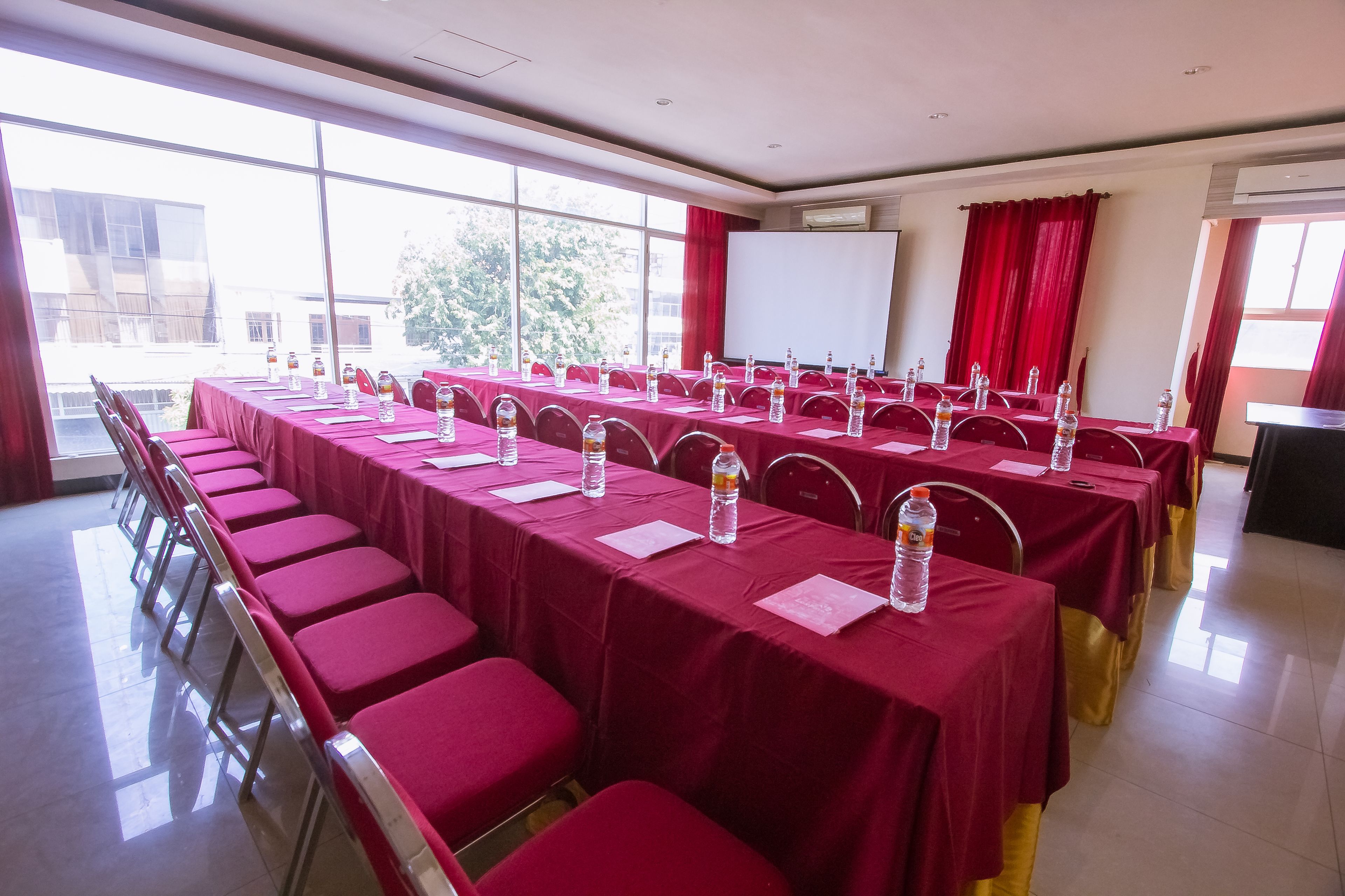 A conference room with long tables, chairs, and a whiteboard.