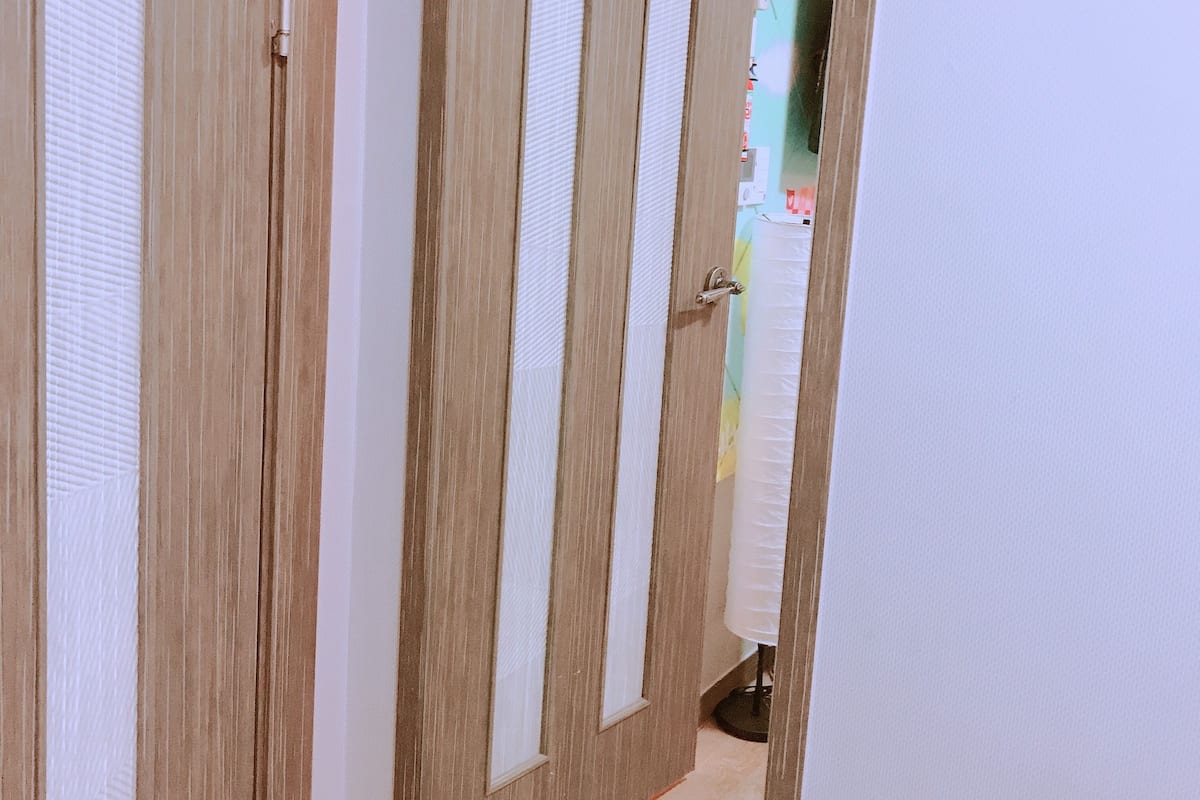 A hallway with wooden doors and a tiled floor.