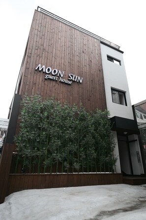 A building with a wooden facade and a sign that reads "MOON SUN Guest House". - Moon Sun Guesthouse (Seoul)