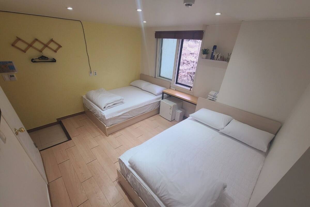 Un dormitorio con dos camas, un escritorio y una ventana.