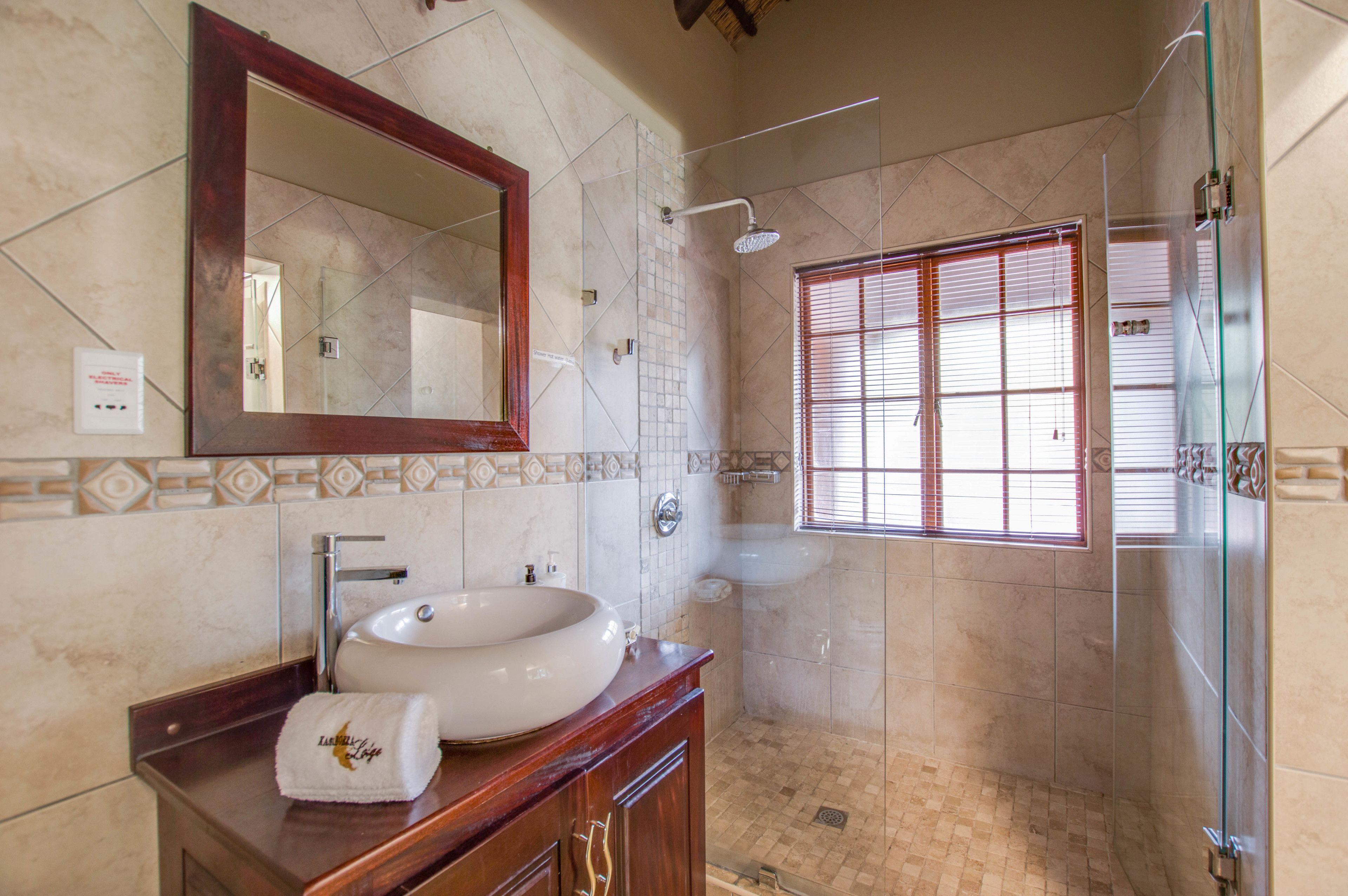 Une salle de bain avec un grand miroir, un lavabo et une douche.