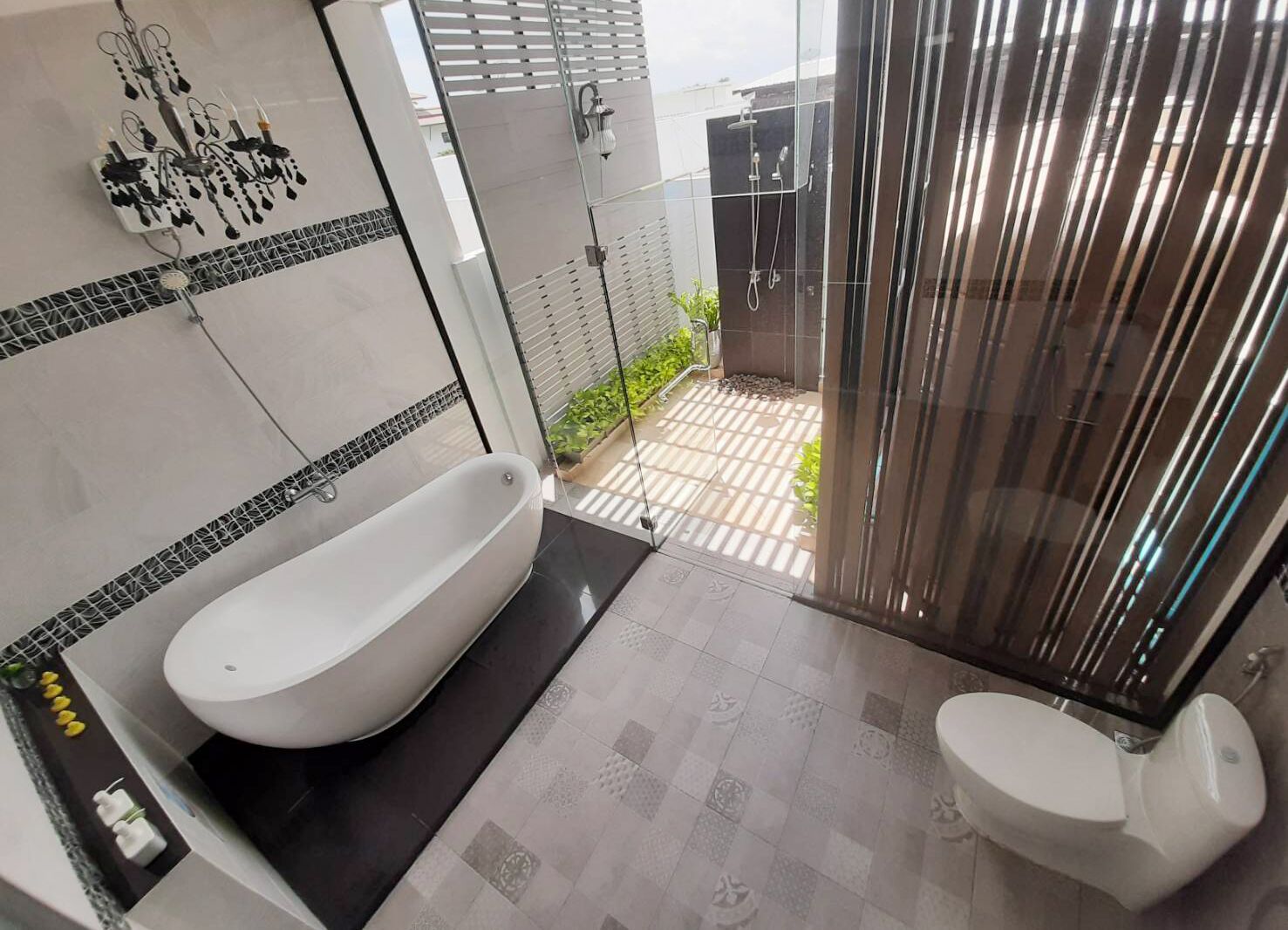 A modern bathroom with a freestanding bathtub, a toilet, and a glass-enclosed shower area.