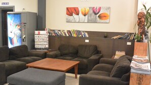 A lounge area with sofas, a coffee table, and a vending machine.
