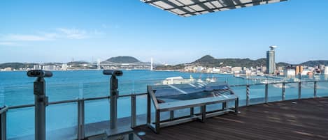 A deck with a view of the water, a landscape guide, and binoculars.