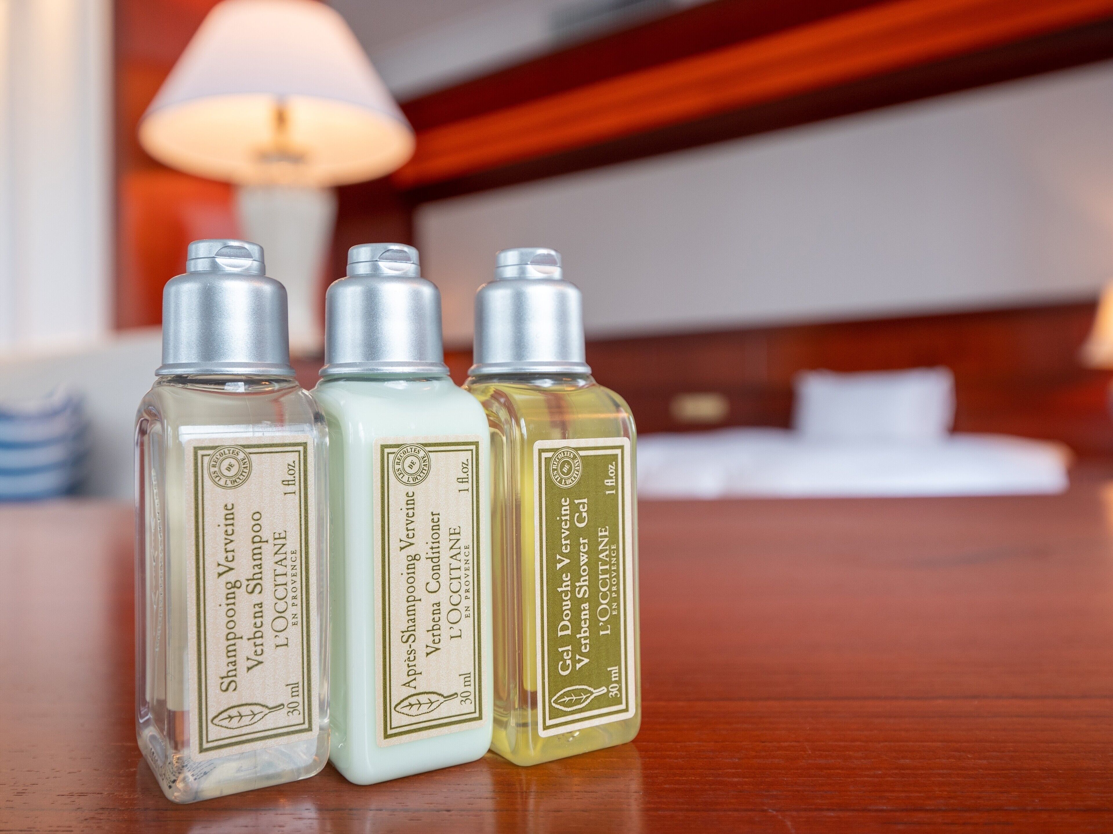 Three bottles of shampoo on a wooden surface.