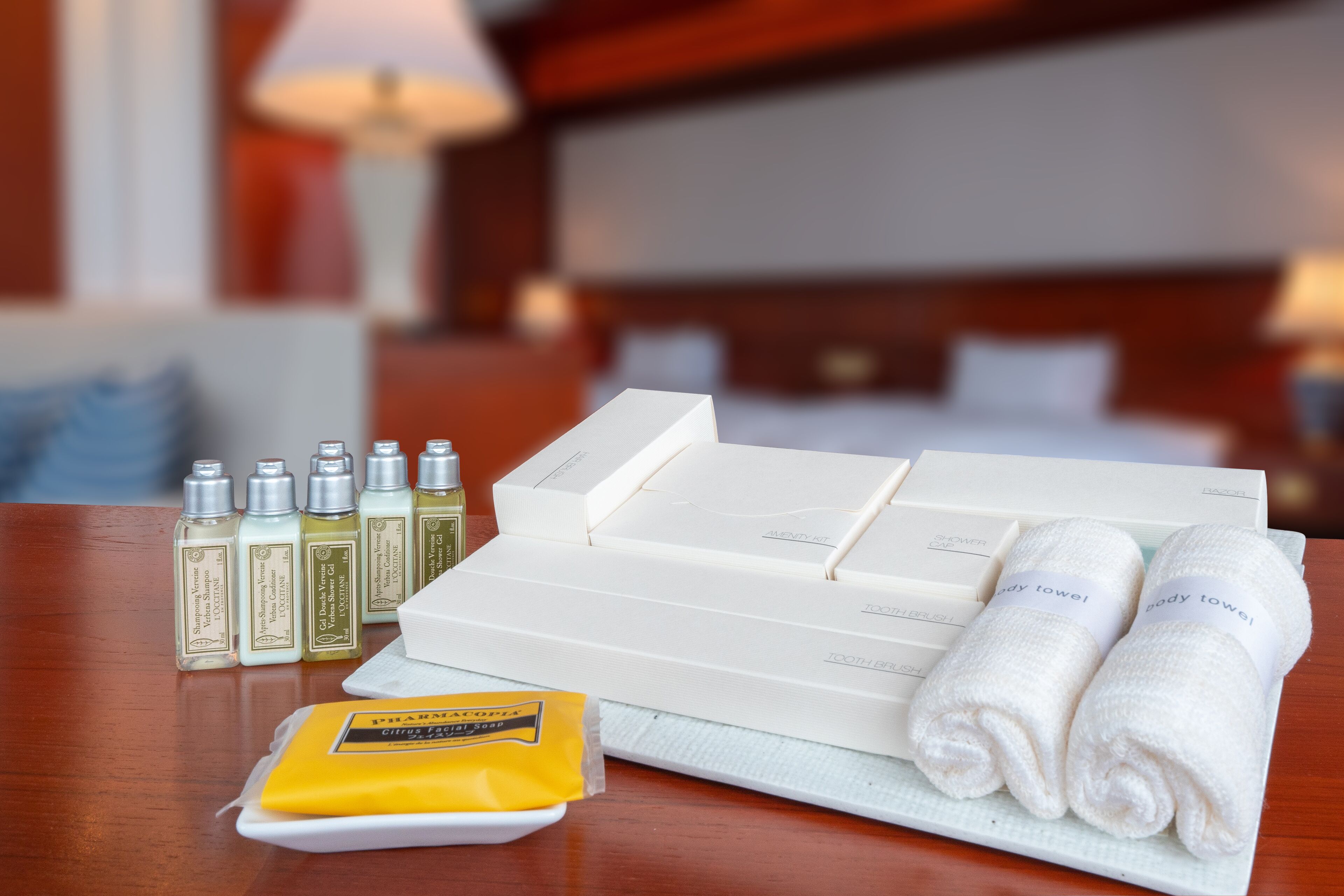 A hotel room with a neatly arranged bathroom vanity, including toiletries and towels.