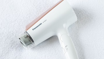 A Panasonic EH-NEST7 hair dryer on a white textured surface.