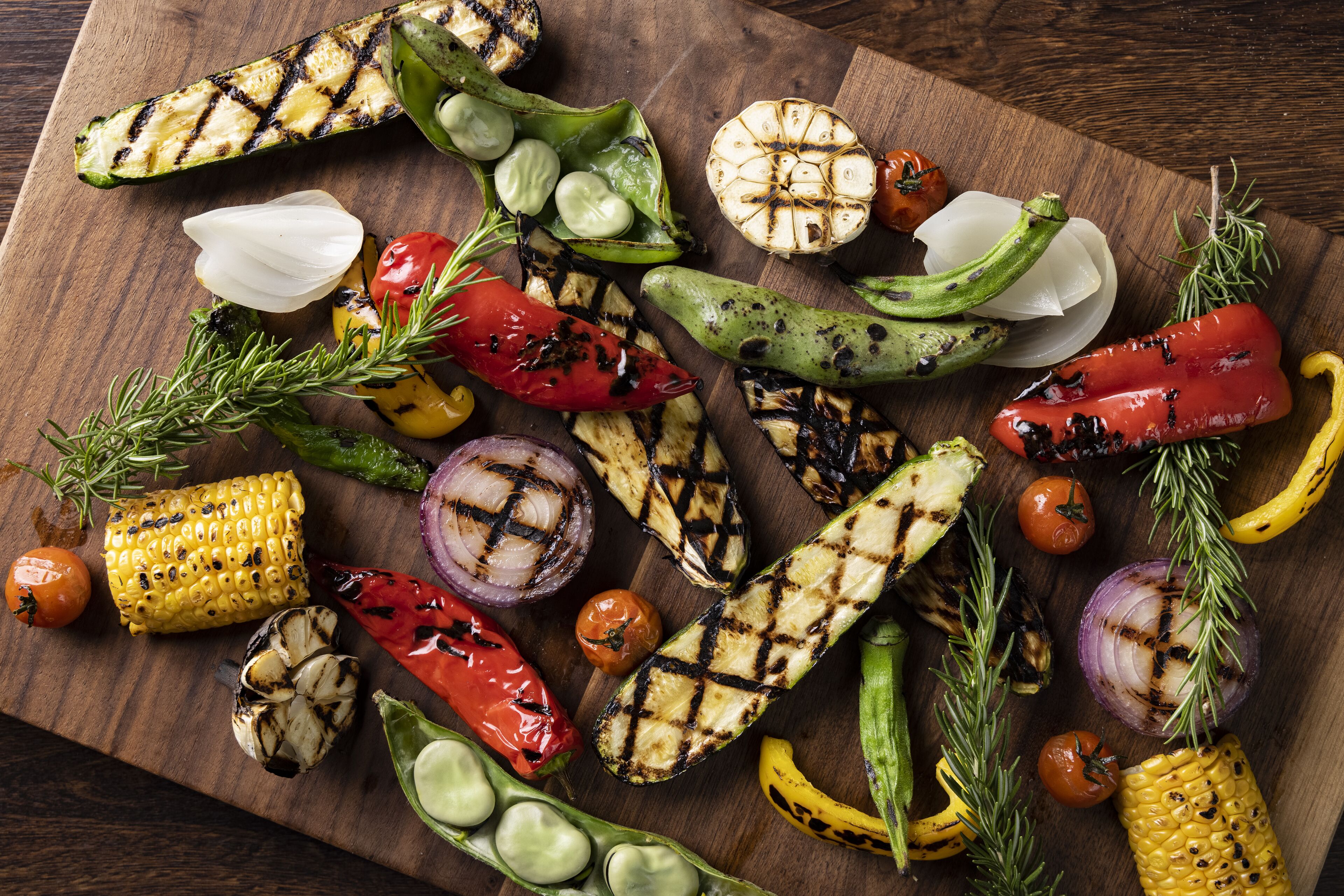 Variedad de verduras a la parrilla sobre una tabla de madera.