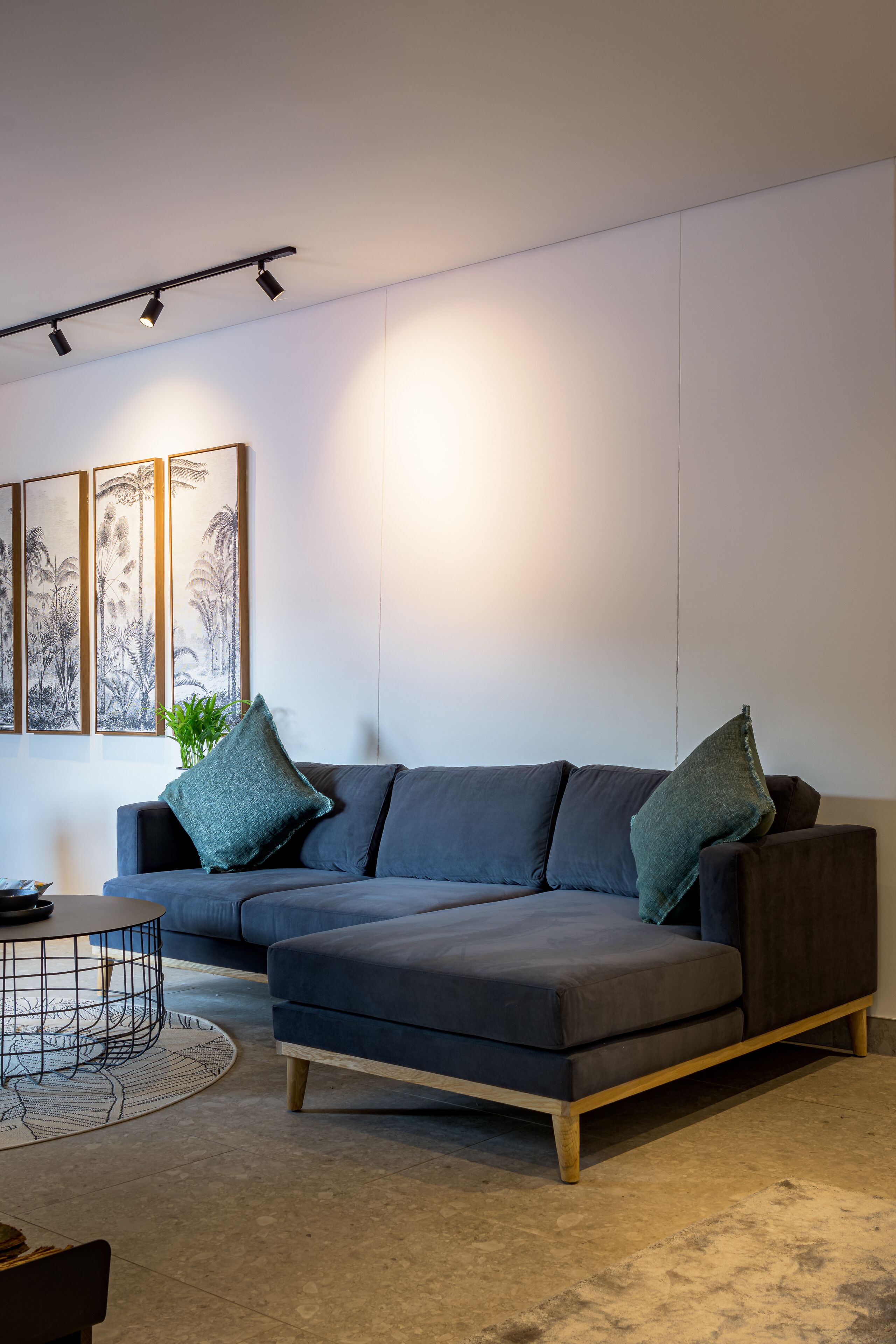 A modern living room with a sectional sofa, a coffee table, and artwork on the wall.