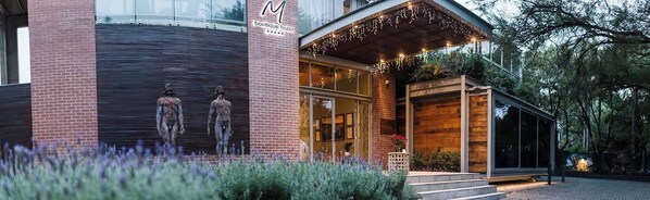 A boutique hotel with a brick facade, large windows, and a wooden entrance. - Menlyn Boutique Hotel (Pretoria)