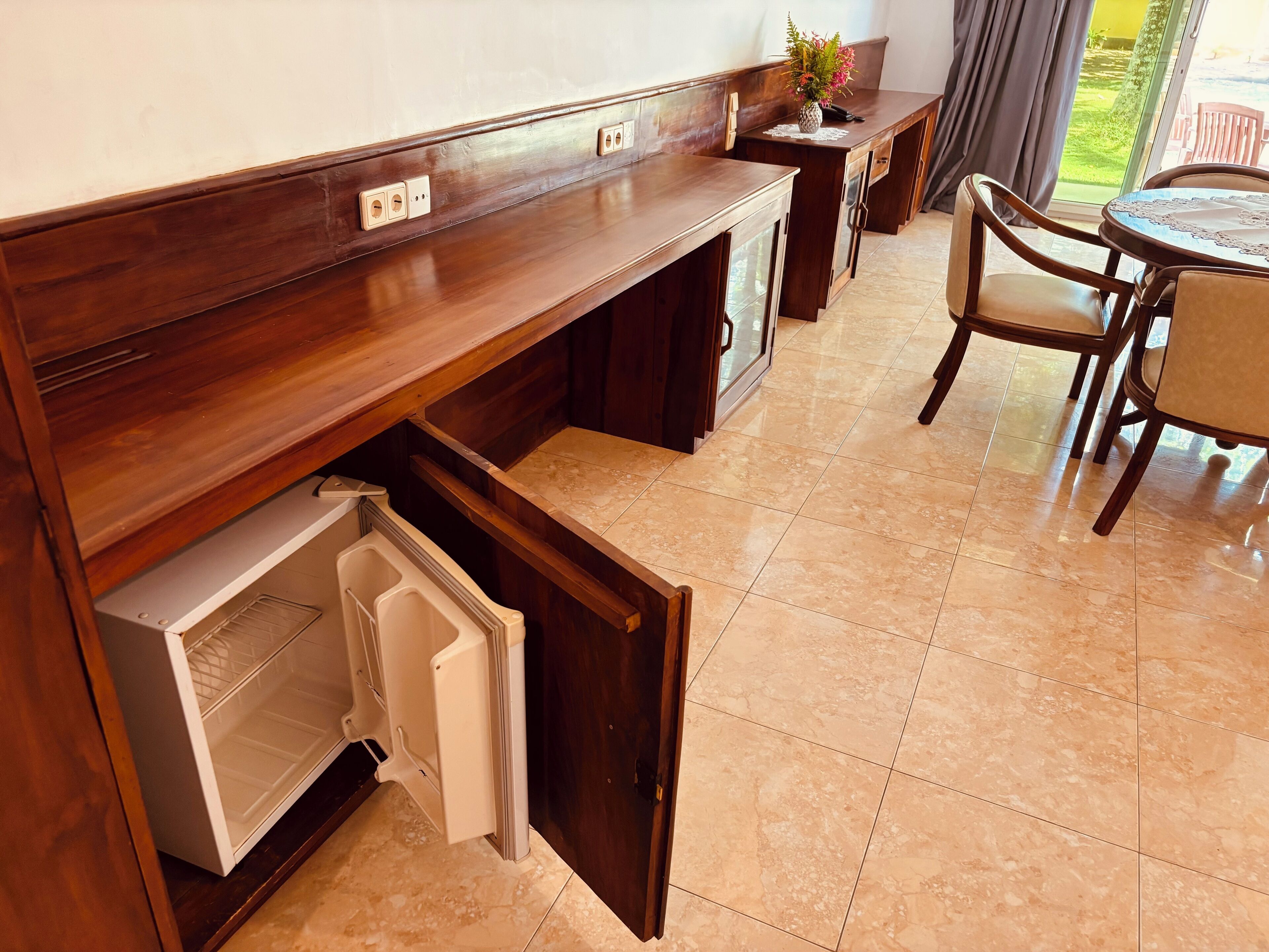 A kitchen with a built-in refrigerator, a wooden countertop, and a dining area with a table and chairs.