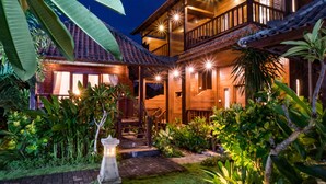 A wooden house with a balcony, surrounded by lush greenery and a brick pathway. - The Cozy Villas Lembongan by ABM (Lembongan Island)