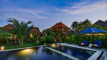 Una piscina al aire libre, sillones reclinables de piscina