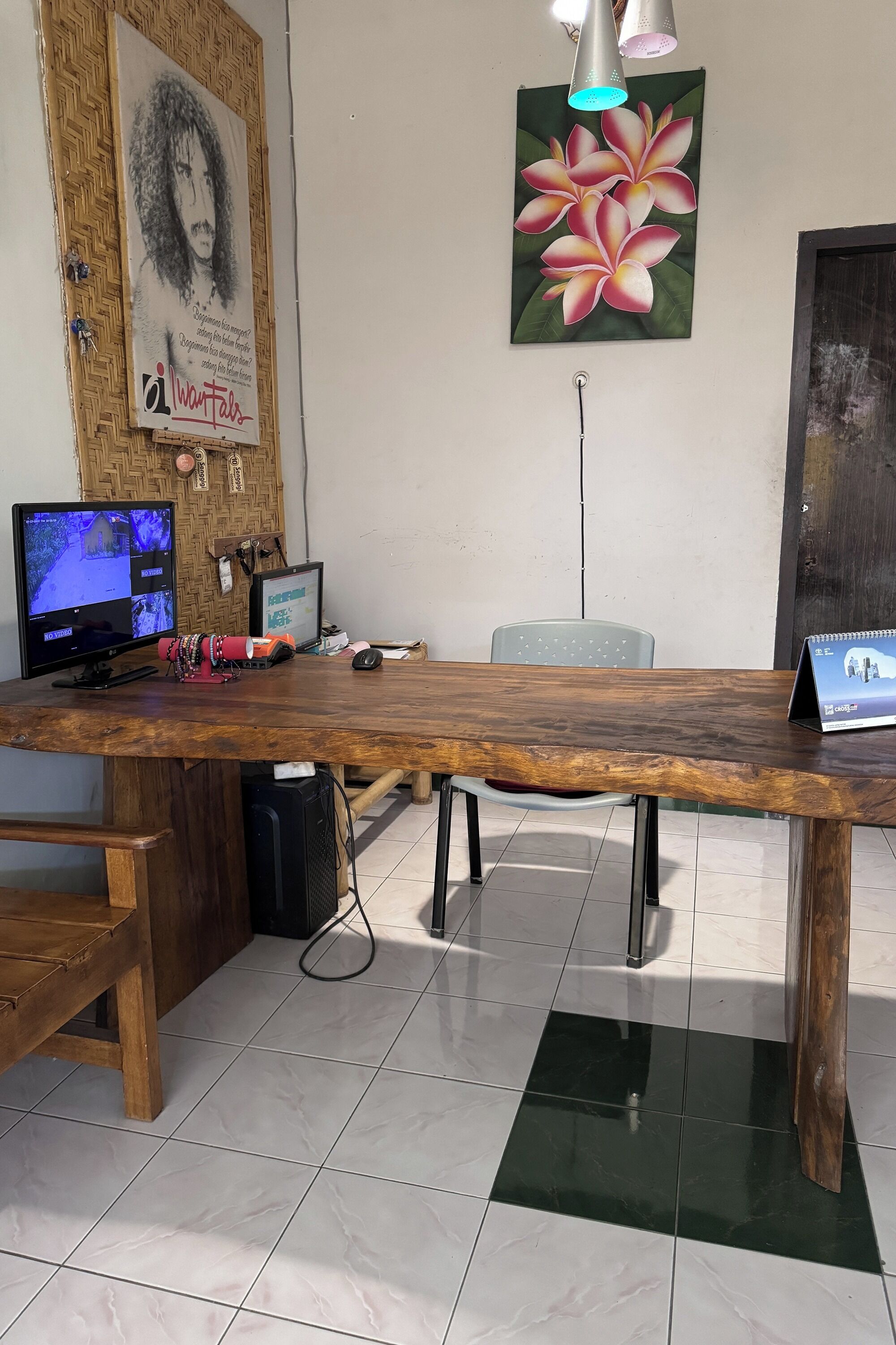 Una mesa de conferencias de madera con dos monitores, una computadora portátil y un cuaderno.
