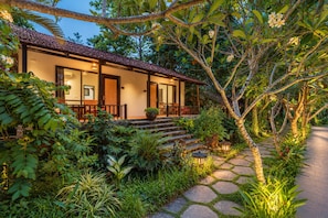 A house with a tiled roof, a porch with seating, and a stone pathway leading to the entrance. - An Nhien Retreat Phu Quoc (Phu Quoc)