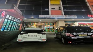 Un edificio de varios pisos con una entrada amplia y un letrero que indica que es un hotel.