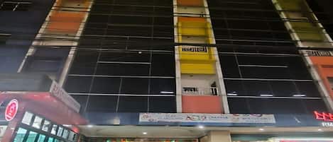 A multi-story building with a large entrance and a sign indicating it is a hotel.