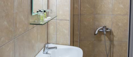 Baño con lavabo, espejo y ducha.