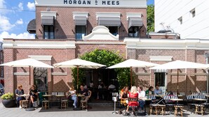 A brick building with the name "MORGAN & MEES" above the entrance. Outside, there are outdoor tables and chairs under umbrellas. - Morgan and Mees Amsterdam (Amsterdam)