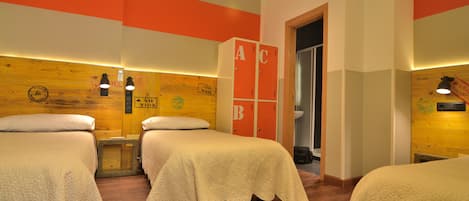 A hotel room with three beds, wooden walls, and orange accents.