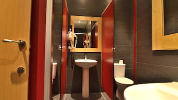 A modern bathroom with a pedestal sink, a toilet, and a bathtub.