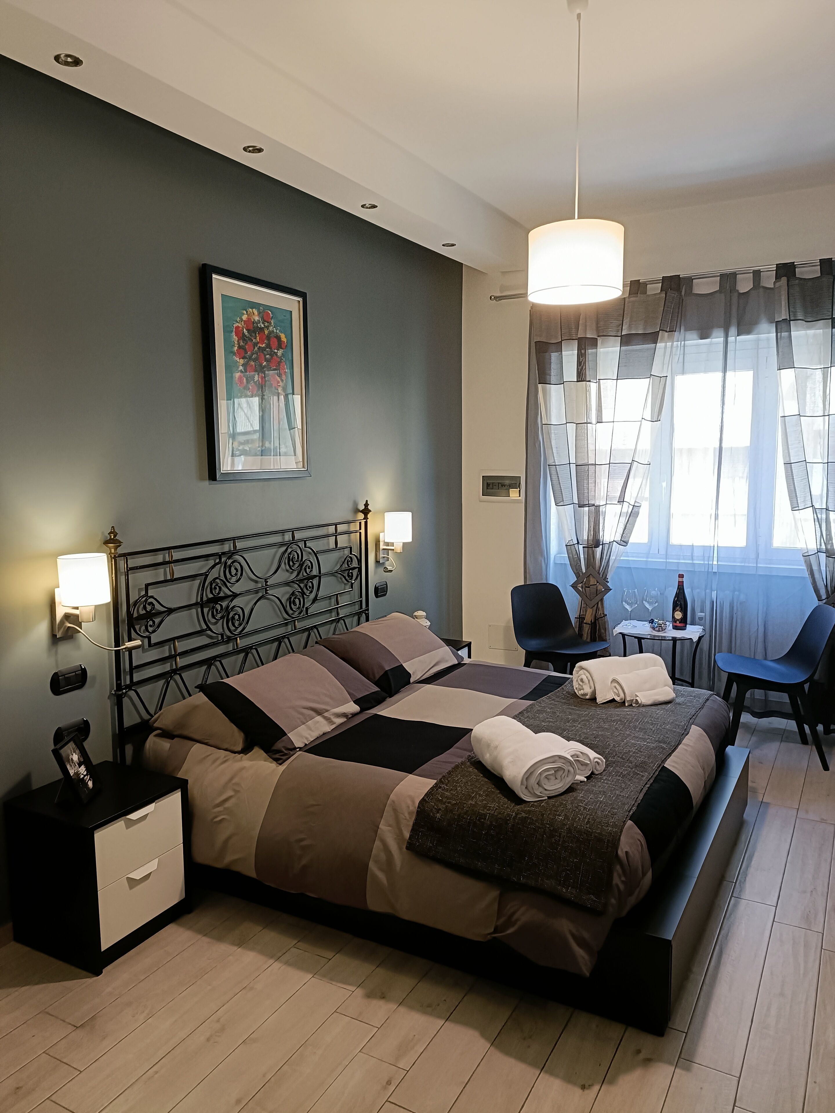 Un dormitorio moderno con una cama grande, mesitas de noche, un escritorio y una silla.