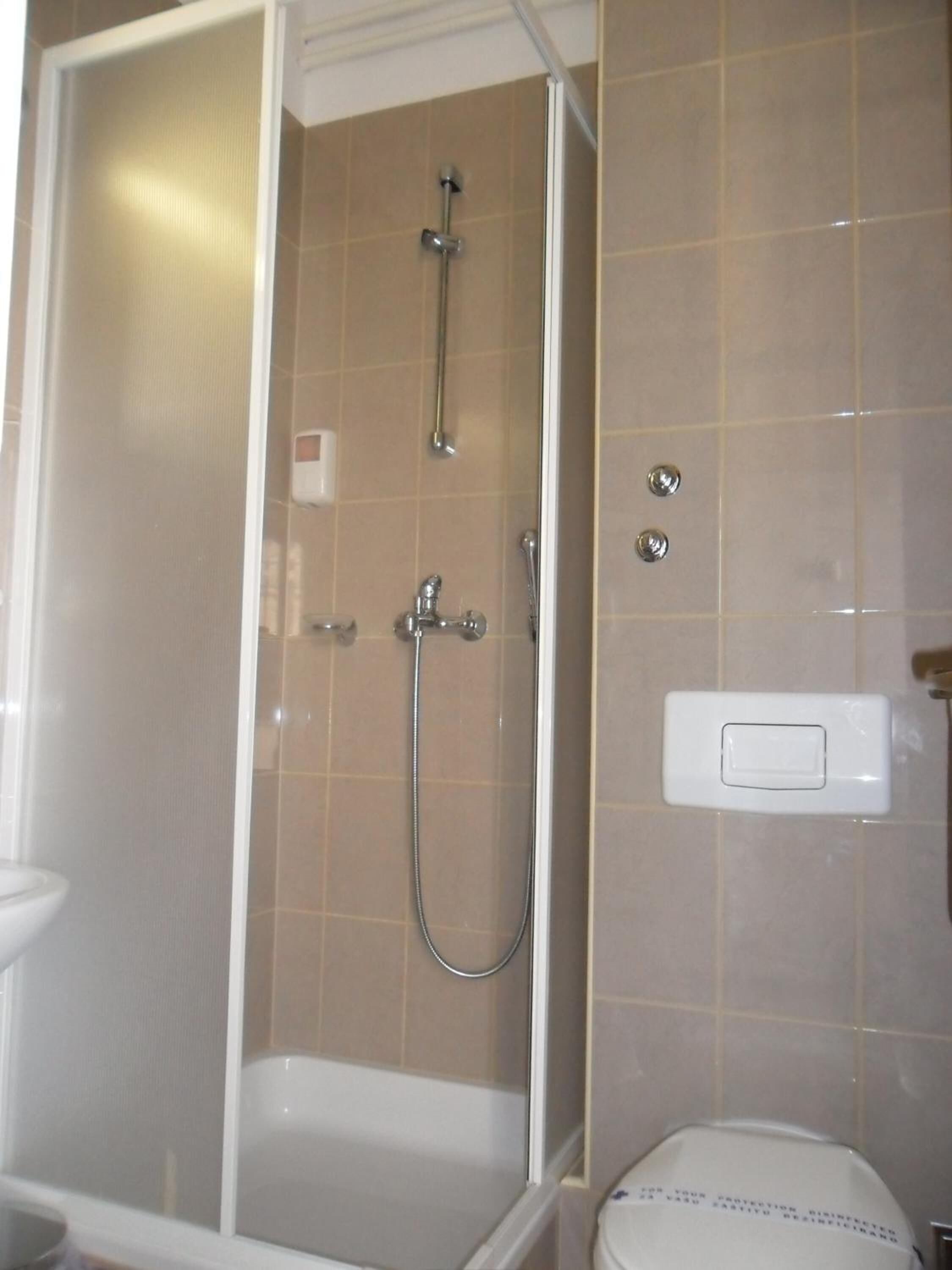 Un baño con cabina de ducha, bañera y retrete.