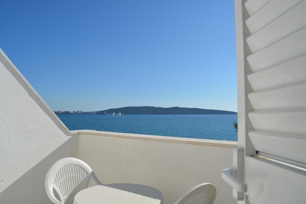 A balcony with a view of the sea, two white chairs, and a small table. - Hotel Ballet School (Kastela)