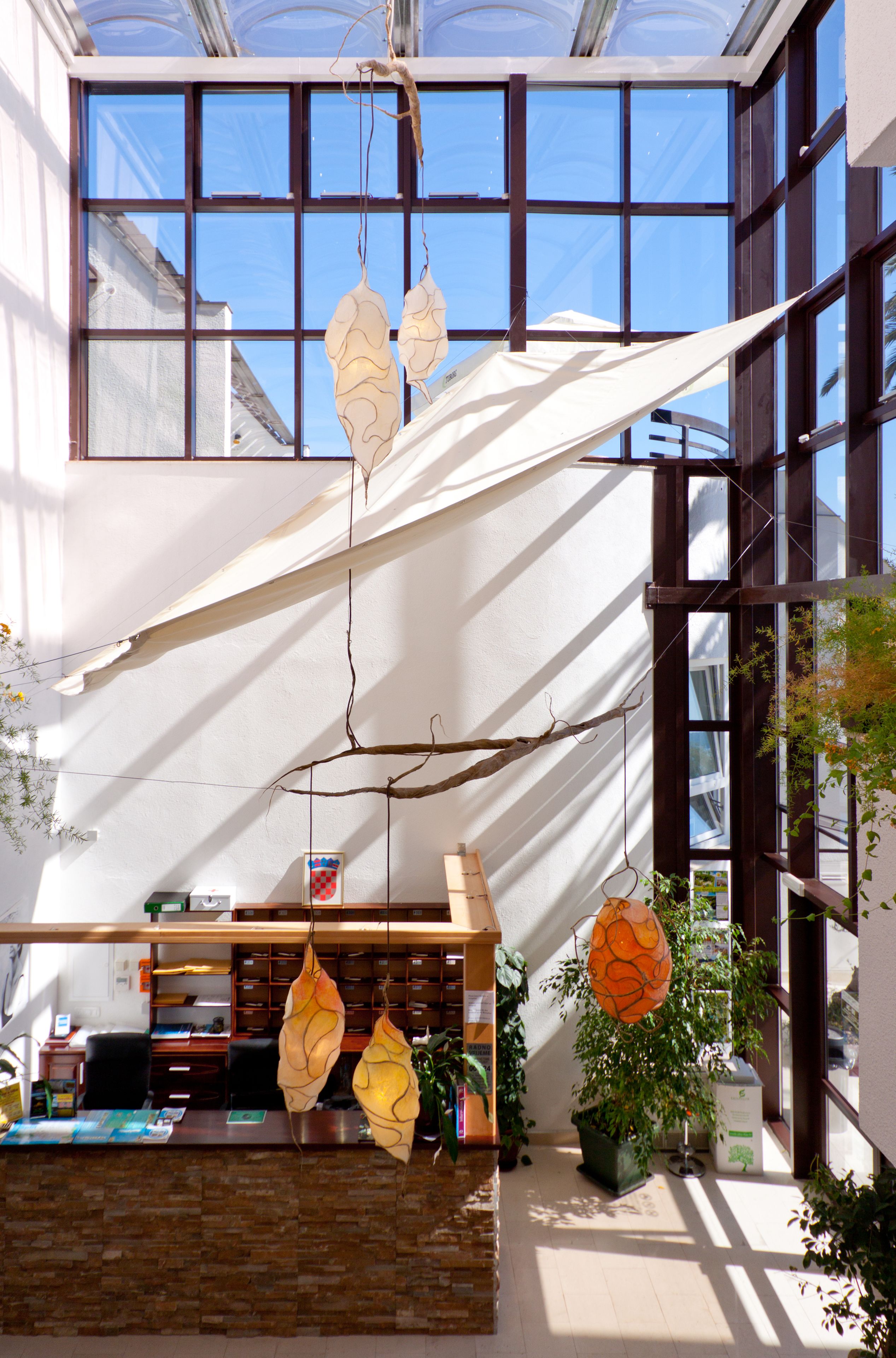 Un espace d’accueil comprenant un comptoir, des chaises et une plante.