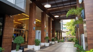 Un edificio moderno con un vestíbulo amplio, columnas imponentes y plantas en macetas.