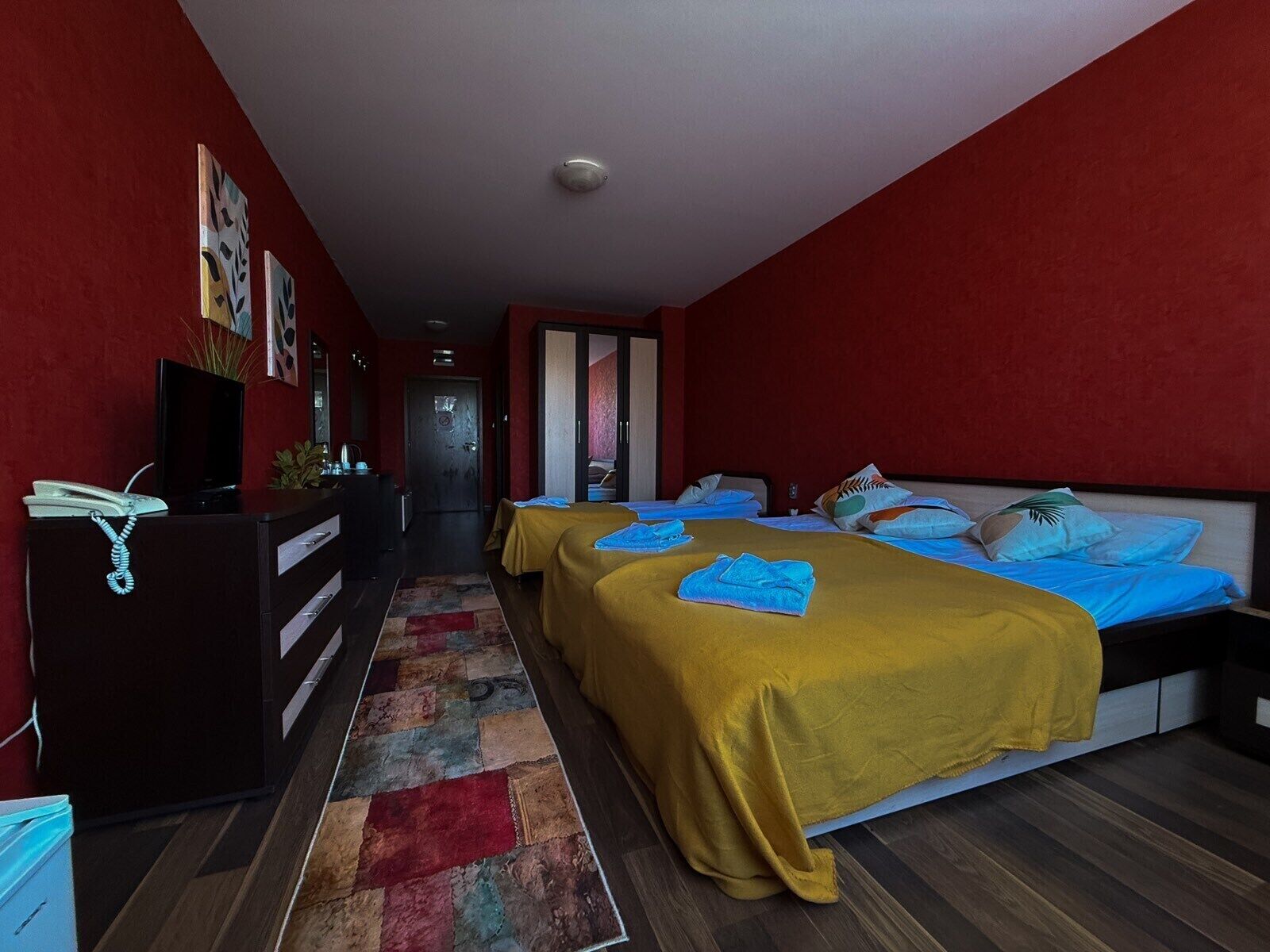 Een hotelkamer met twee bedden, een bureau en een kledingkast.