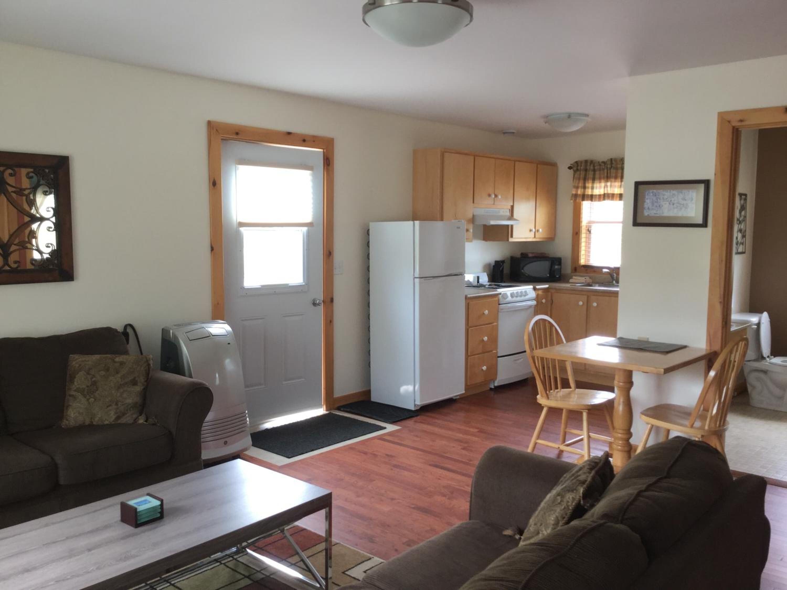 A compact living space with a kitchenette, a dining area, and a seating area.