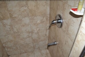 Habitación triple Deluxe, varias camas, con acceso para personas discapacitadas | Baño | Regadera, regadera tipo lluvia, amenidades de baño gratuitas 