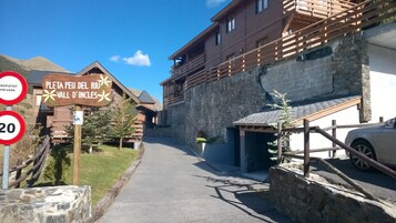Un camino estrecho que conduce a un edificio de madera con un cartel que indica 'Pletta Peu del Riu Vall d'Angles'.