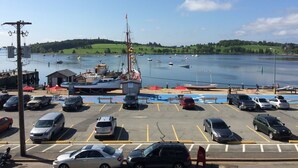 A parking lot with cars and a dock with boats. - The Dockside Inn & Restaurant (Lunenburg)
