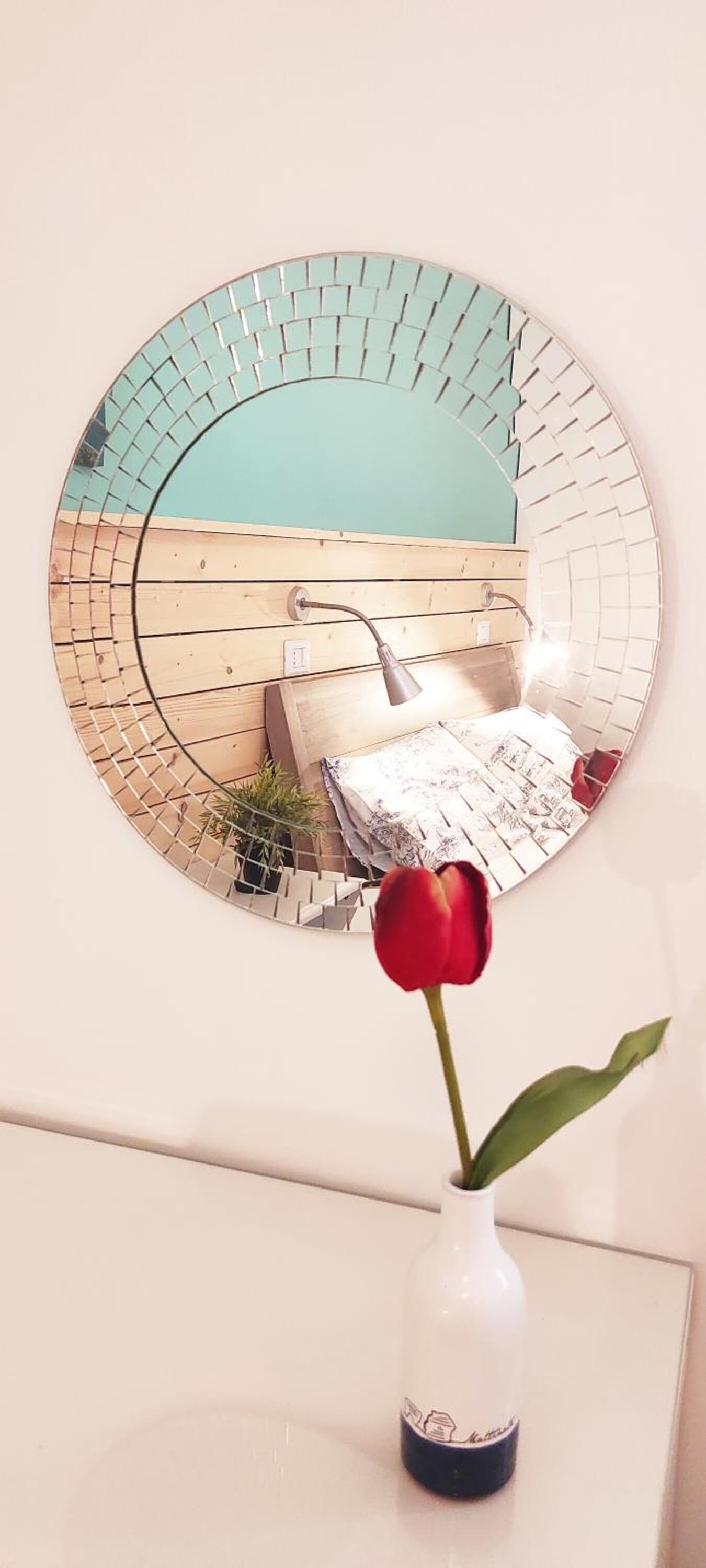 A round mirror with a geometric pattern on a wall.