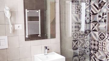 A modern bathroom with a glass shower enclosure, a white sink, and a toilet.