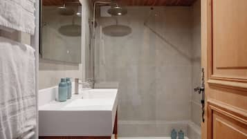 Un baño moderno con dos lavamanos, ducha y un mueble de madera.