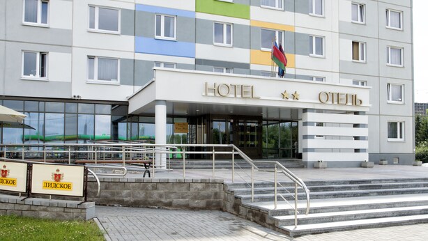 A modern hotel building with a sign reading "HOTEL" and a flag above the entrance. - Sport Time Hotel (Minsk)